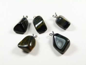 Pięć ciemnych, polerowanych kamieni z zawieszkami leży na białym tle.