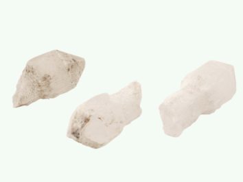 Kwarc sceptre/ kwarc berłowy - kamień naturalny, surowy, nieszlifowany. Trzy białe kryształy kwarcu na jasnym tle.