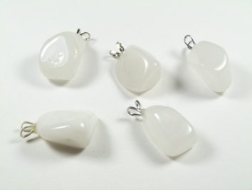 Pięć białych kamieni z zawieszkami ułożonych na białym tle.