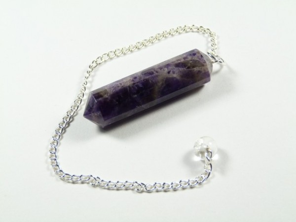 Fioletowy wahadełko z ametystu na srebrnym łańcuszku leży na białym tle.