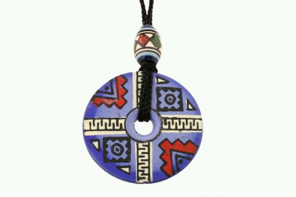 Okrągły, niebieski wisiorek z geometrycznym wzorem na czarnym sznurku.