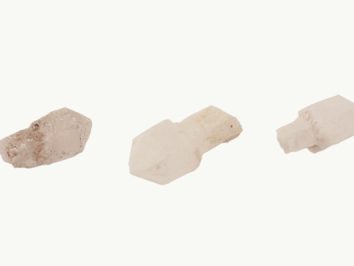 Kwarc sceptre/ kwarc berłowy - kamień naturalny, surowy, nieszlifowany. Trzy kryształy kwarcu leżące obok siebie na białym tle.