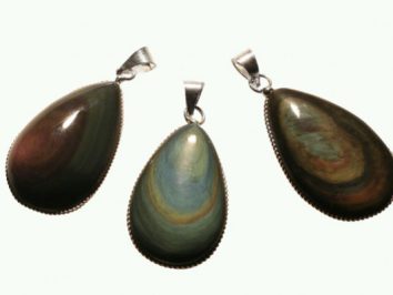 Trzy wisiorki z kamieniami w kształcie łezki na białym tle.