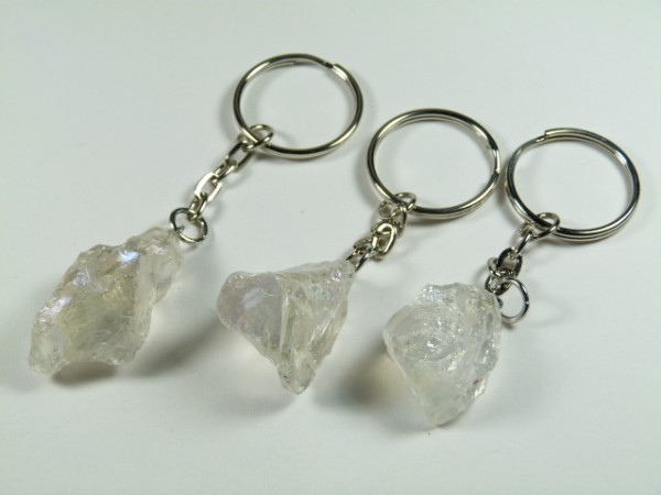 Trzy breloki z przezroczystymi, surowymi kryształami na metalowych kółkach.