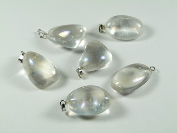 Sześć przezroczystych kamieni z zawieszkami leży na białym tle.