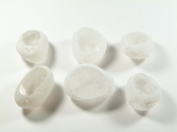 Sześć nieregularnych bryłek lodu na białym tle.