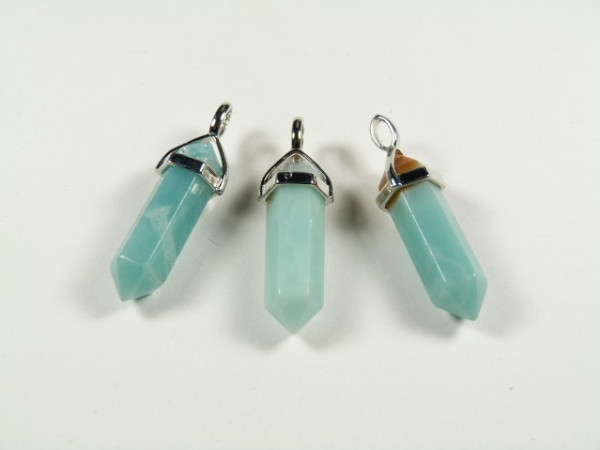 Trzy miętowe kamienie w kształcie wisiorów z metalowymi okuciami leżą na białym tle.