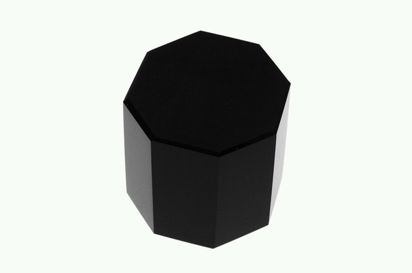 Czarny ośmiokątny blok stoi na jasnym tle.