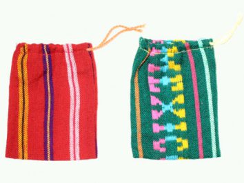 Dwa kolorowe woreczki z tkaniny z wzorami, leżące obok siebie na jasnym tle.