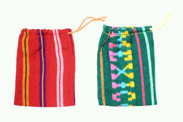 Dwa kolorowe woreczki z tkaniny z wzorami, leżące obok siebie na jasnym tle.