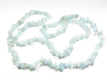 Naszyjnik z drobnych, nieregularnych, jasnoniebieskich kamieni na białym tle.