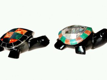 Dwie figurki żółwi z kolorowymi skorupami ustawione obok siebie na jasnym tle.