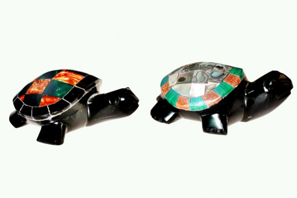Dwie figurki żółwi z kolorowymi skorupami ustawione obok siebie na jasnym tle.