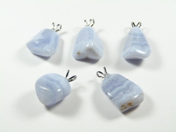 Pięć niebieskich wisiorków z kamieniami leży na białym tle.