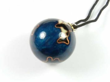 Granatowy, kulisty wisiorek na czarnym sznurku, ozdobiony złotymi liniami.