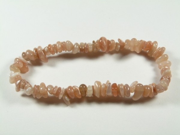 Bransoletka z różowych kamieni na elastycznej żyłce, ułożona na białym tle.