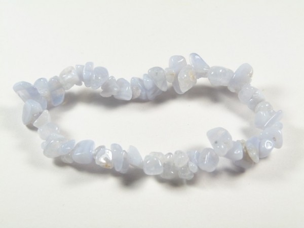 Bransoletka z niebieskich, nieregularnych kamieni na białym tle.