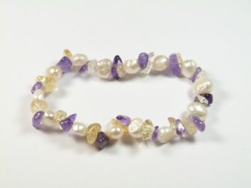 Bransoletka z pereł, ametystów i cytrynów ułożona na białym tle.
