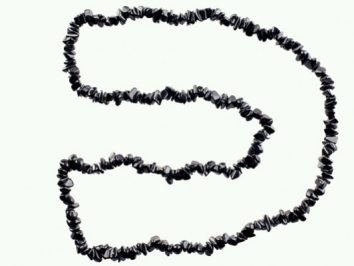Naszyjnik z czarnych, nieregularnych kamieni ułożony w kształt litery „D” na jasnym tle.
