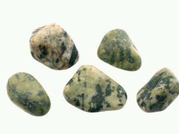 Pięć gładkich, zielonych kamieni z ciemniejszymi plamkami na jasnym tle.