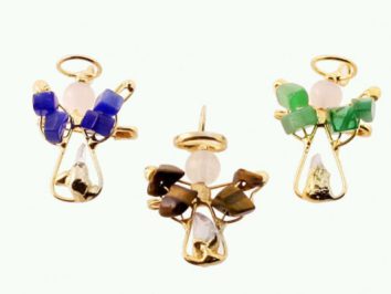 Trzy aniołki z kolorowych kamieni i złotego drutu na jasnym tle.