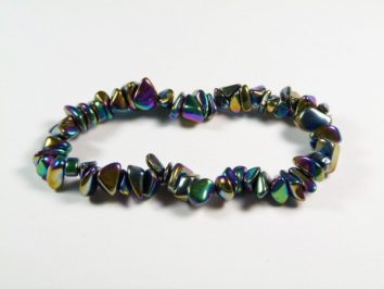 Bransoletka z kolorowych, nieregularnych kamieni na białym tle.