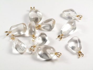 Przezroczyste zawieszki z kamieni górskich z metalowymi uchwytami na białym tle.