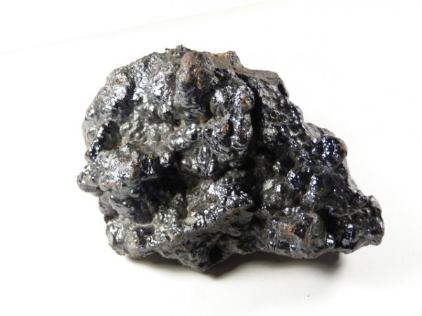 Hematyt - kamień naturalny, surowy, nieszlifowany. Czarny, błyszczący okaz minerału hematytu na białym tle.