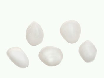 Awenturyn biały - kamień gładzony, polerowany, szlifowany i bębnowany w formie otoczaka. Pięć białych kamieni na jasnym tle.