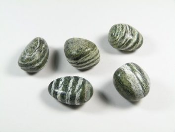 Pięć zielonych, pasiastych kamieni leży na białym tle.