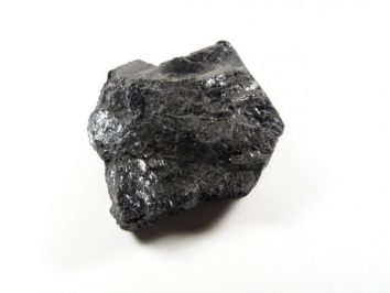 Czarny kawałek węgla kamiennego na białym tle.