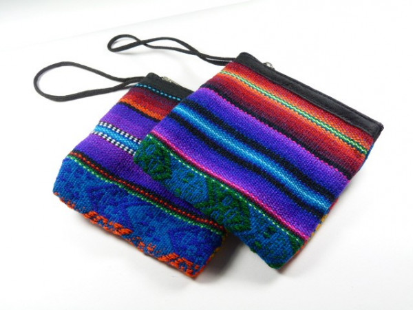 Dwie kolorowe torebki materiałowe z wzorami etnicznymi leżą obok siebie na białym tle.