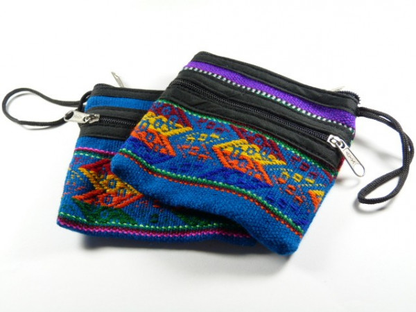Dwie kolorowe, tkane saszetki z zamkami błyskawicznymi leżą na białym tle.