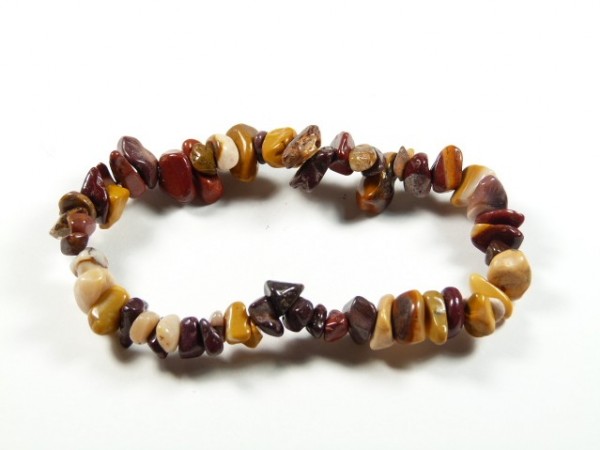 Bransoletka mookait. Bransoletka z drobnych, wielokolorowych kamieni na elastycznej żyłce, na białym tle.