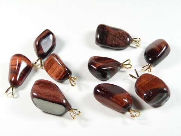 Osiem brązowych kamieni z zawieszkami do biżuterii leży na białym tle.