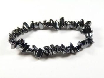Bransoletka z czarnych, nieregularnych kamieni hematytu na elastycznej żyłce, na białym tle.