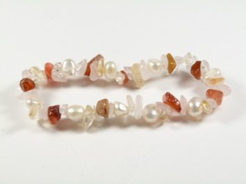 Bransoletka z kolorowych kamieni oraz perełek, ułożona na białym tle.