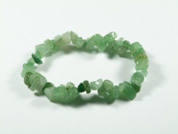 Bransoletka z zielonych, nieregularnych kamieni na białym tle.