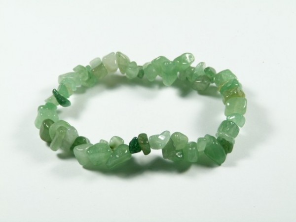 Bransoletka z zielonych, nieregularnych kamieni na białym tle.