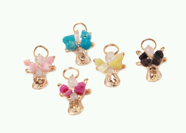 Pięć kolorowych zawieszek aniołków z koralikami ułożonych na białym tle.
