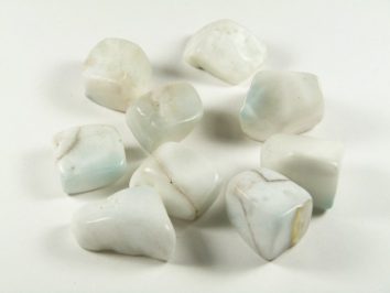 Kilka białych, gładkich kamieni leży na jasnym tle.