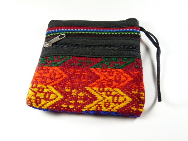 Mała, kolorowa torebka z dwoma zamkami błyskawicznymi i etnicznym wzorem na tkaninie.