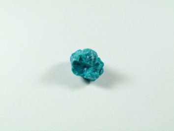 Chryzokola. Niebieski kamień mineralny leży na białym tle.