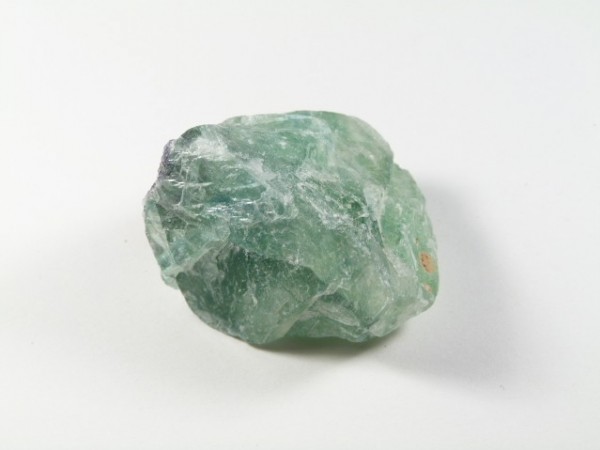 Zielony, surowy kamień fluorytu na białym tle.