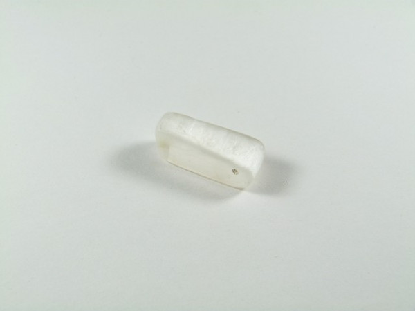 Biała kostka mydła leży na białym tle.