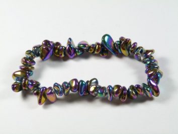 Bransoletka z kolorowych, nieregularnych koralików na białym tle.