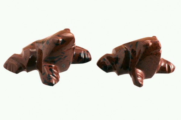 Dwa brązowe figurki żab wykonane z kamienia, ustawione obok siebie na jasnym tle.