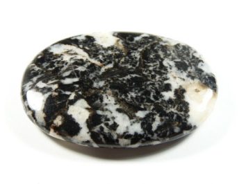 Owalny, polerowany kamień o czarno-białym, marmurkowym wzorze na białym tle.