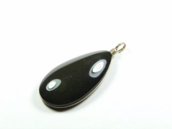 Czarny wisior z oczkami, w kształcie łzy, z metalowym uchwytem na biały tle.