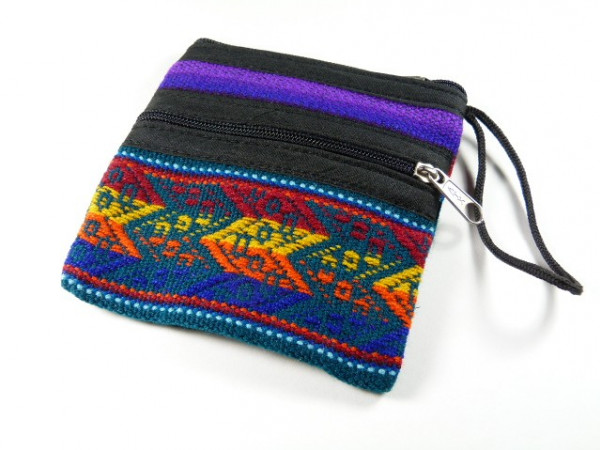 Mała torebka z kolorowym, etnicznym wzorem i zamkiem błyskawicznym, leży na białym tle.